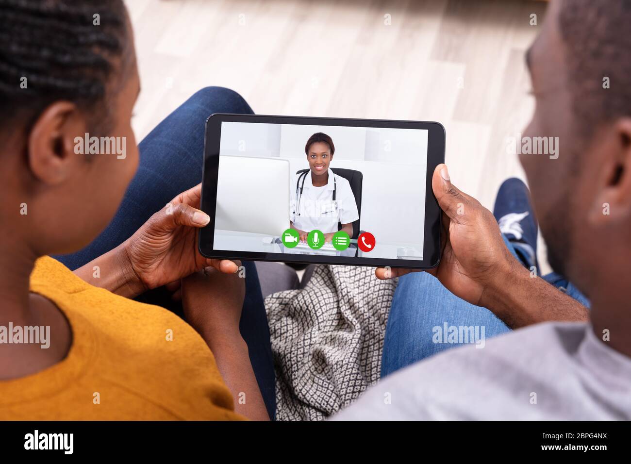 Gros plan d'un couple africain la visioconférence avec Happy Female Doctor on Digital Tablet Banque D'Images