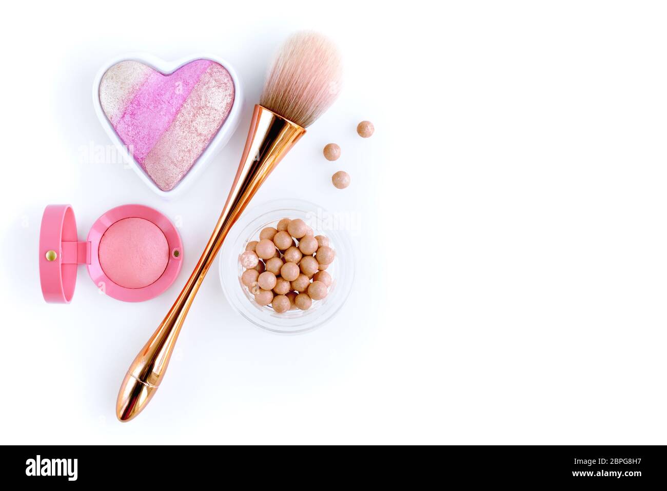 Boules de poudre cosmétiques et pinceau à maquillage, blush, surligneur, isolé sur fond blanc, avec espace vide pour le texte. Vue de dessus Banque D'Images