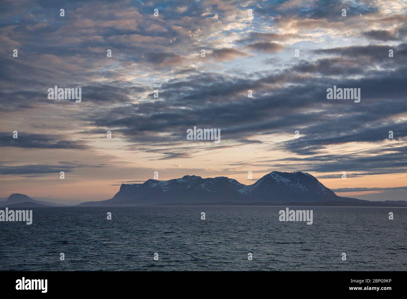 Îles au large de la côte ouest de la Norvège septentrionale, vues par la lumière du soleil de minuit avec un ciel et des nuages spectaculaires Banque D'Images