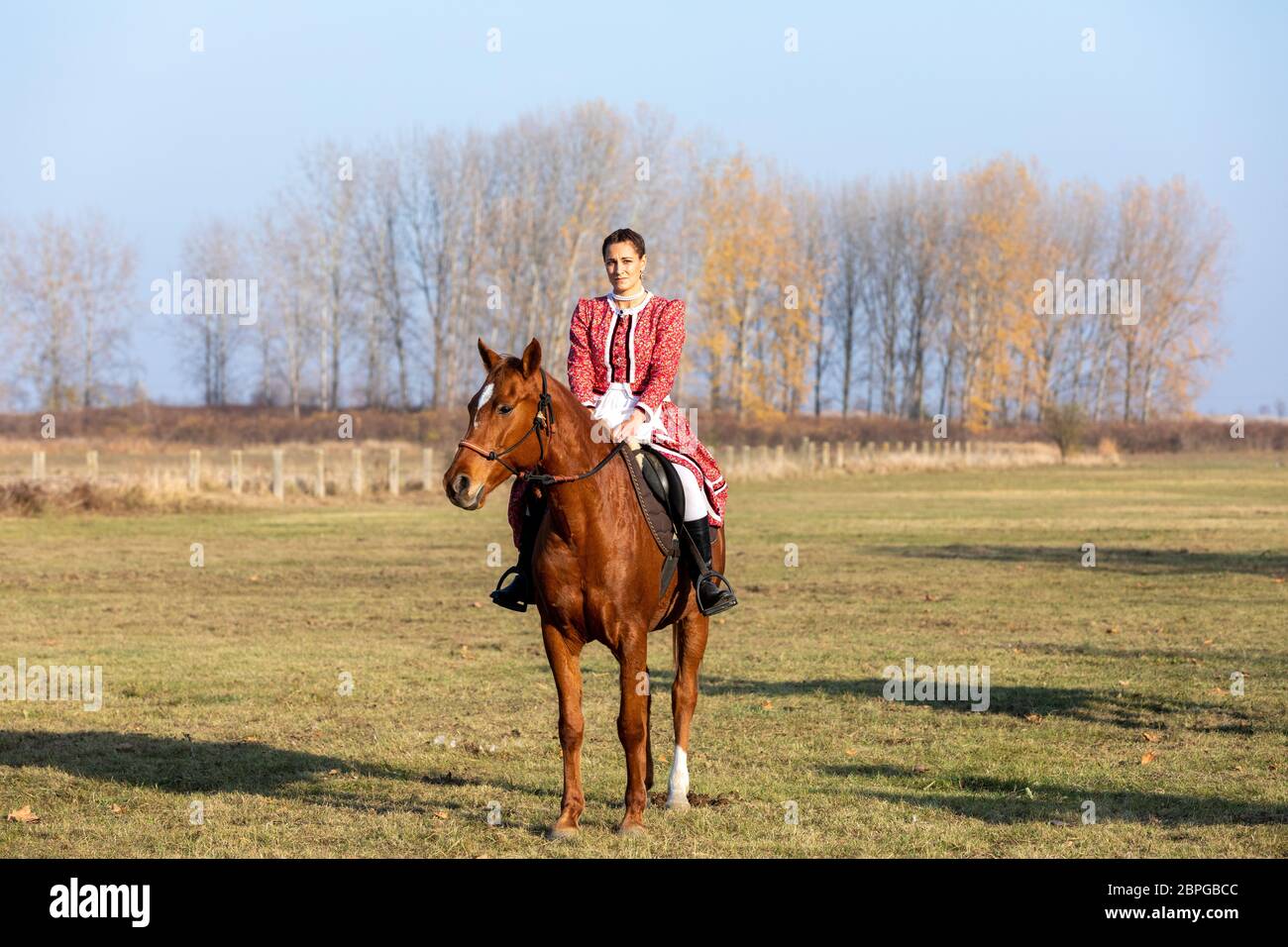 HORTOBAGY, HONGRIE, NOVEMBRE 04. 2018: Femme hongroise csikos en costume traditionnel folklorique à cheval son cheval entraîné. Novembre 04. 2018, Hortobagy, Hun Banque D'Images