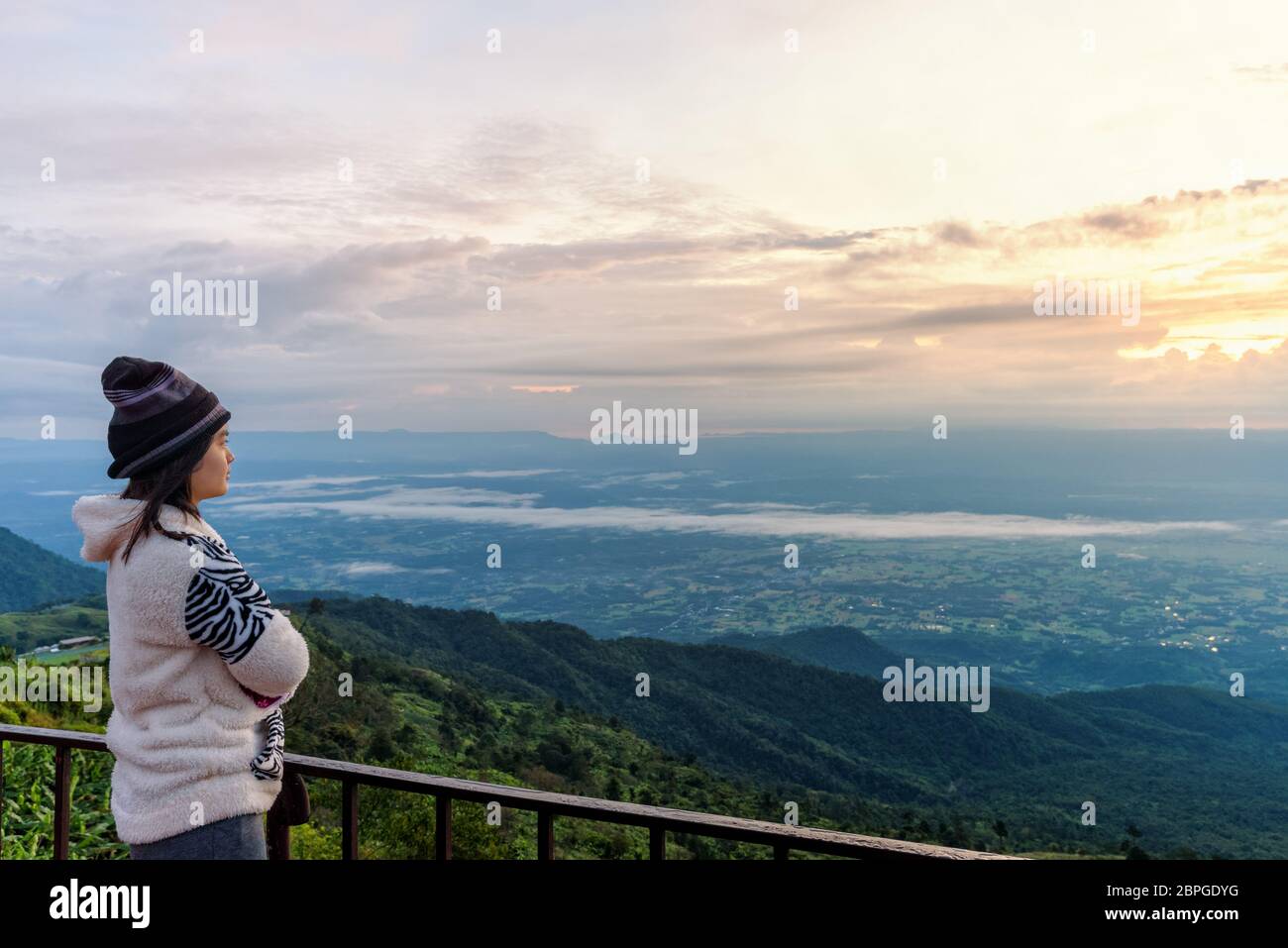 Touriste dans un article la robe pull en regardant le magnifique paysage naturel de la forêt et montagne pendant le lever du soleil sur le haut sommet en th Banque D'Images