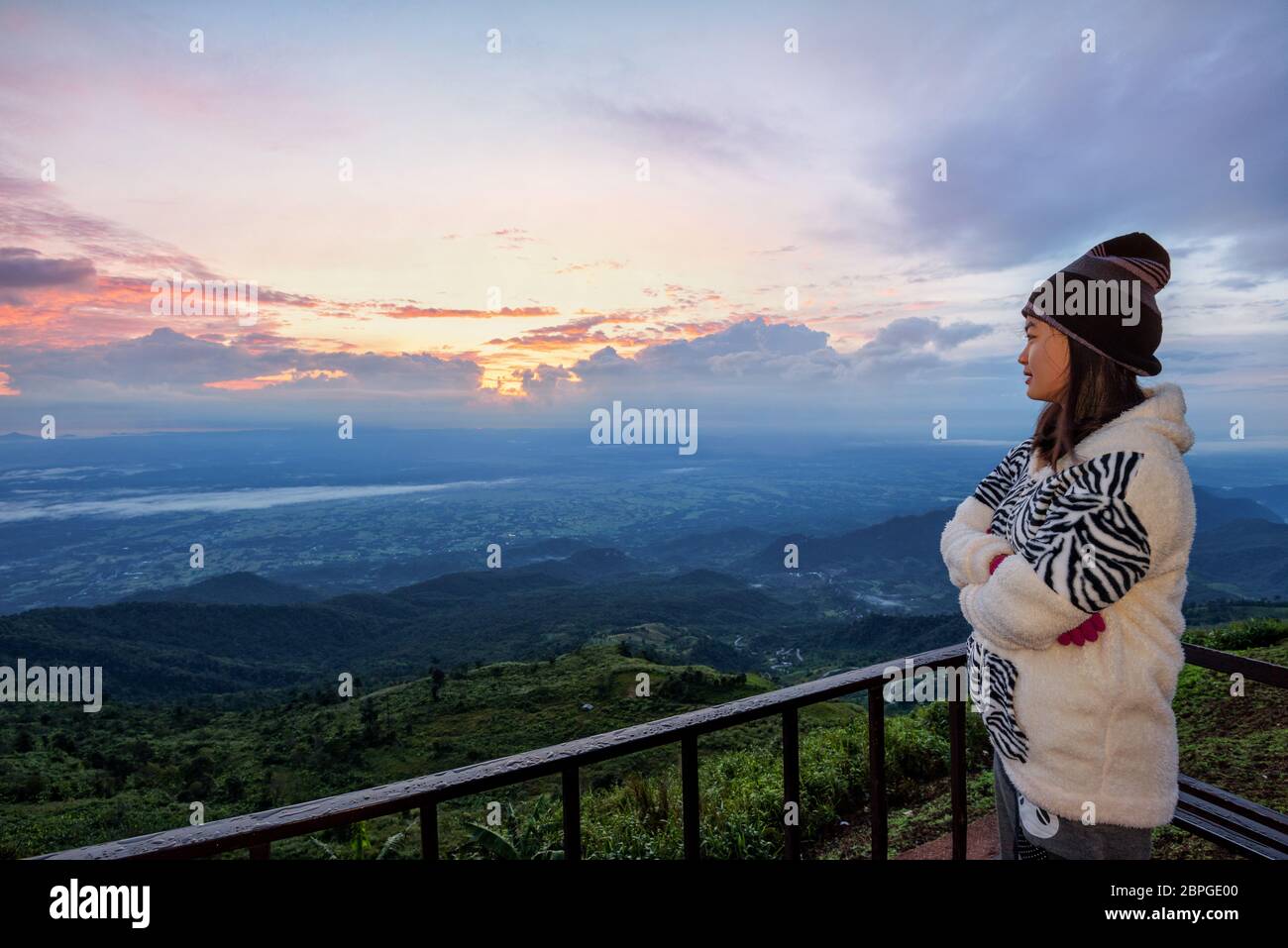 Touriste dans un article la robe pull en regardant le magnifique paysage naturel de la forêt et montagne pendant le lever du soleil sur le haut sommet en th Banque D'Images