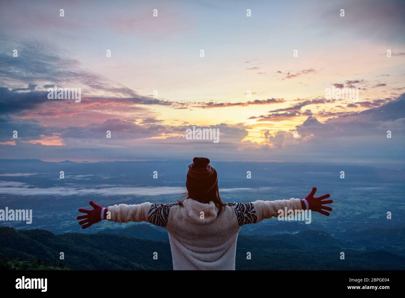 Touriste dans un article robe pull bras tendus, heureux tout en regardant le magnifique paysage naturel de la forêt et montagne au cours de la Banque D'Images