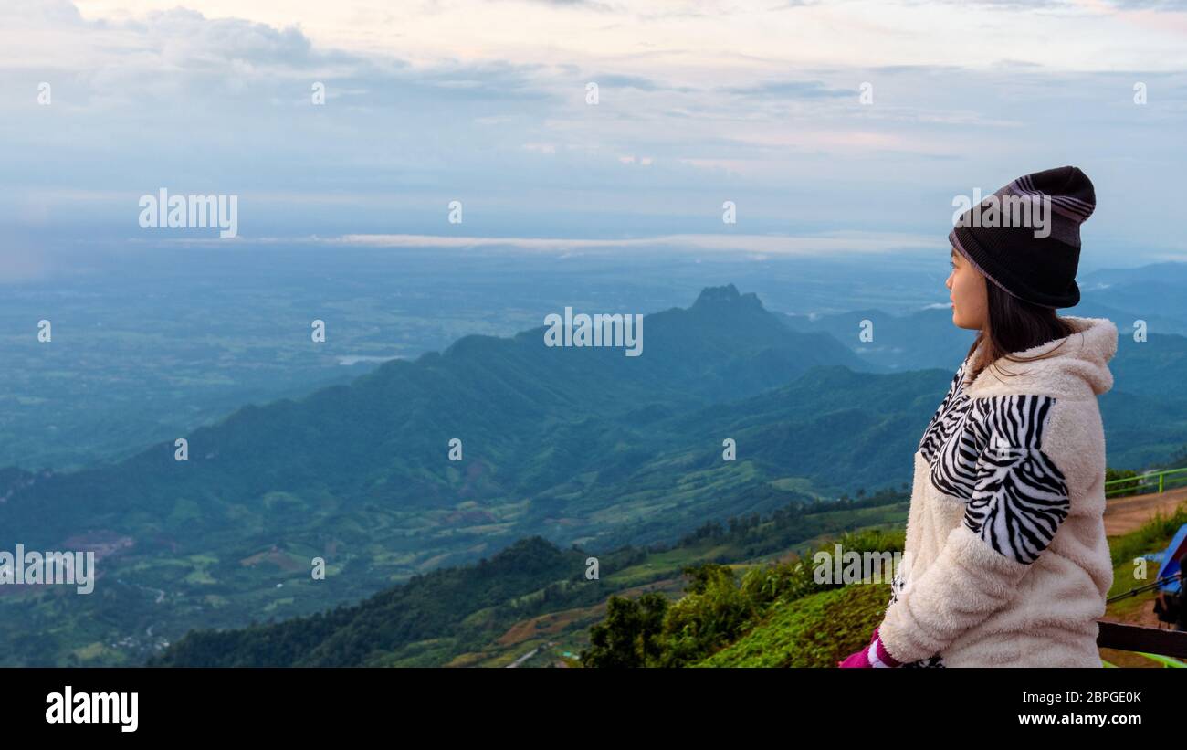 Touriste dans une belle robe pull regardant le paysage de la nature de la forêt et montagne au cours du lever du soleil à Phu Thap Boek Viewpoint Phet Banque D'Images