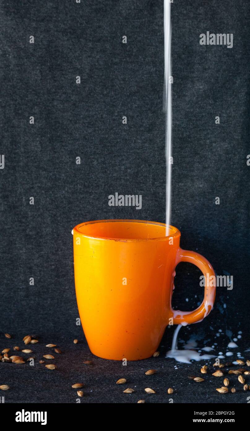 le lait s'est répandu dans la tasse orange Banque D'Images