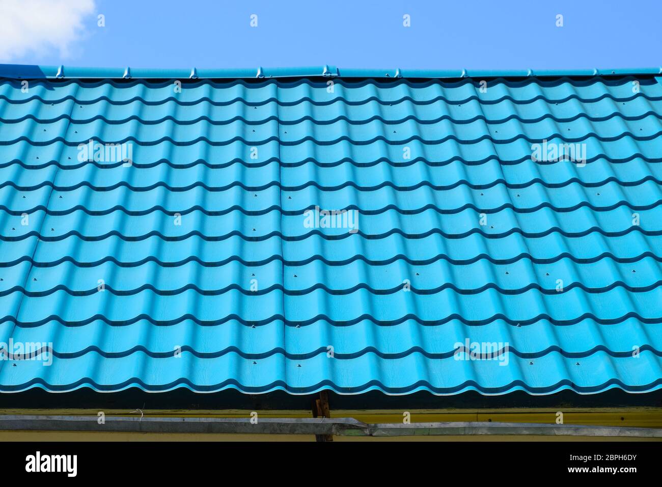 Carreaux de métal turquoise sur le toit de la maison. Matériaux de toiture modernes Banque D'Images