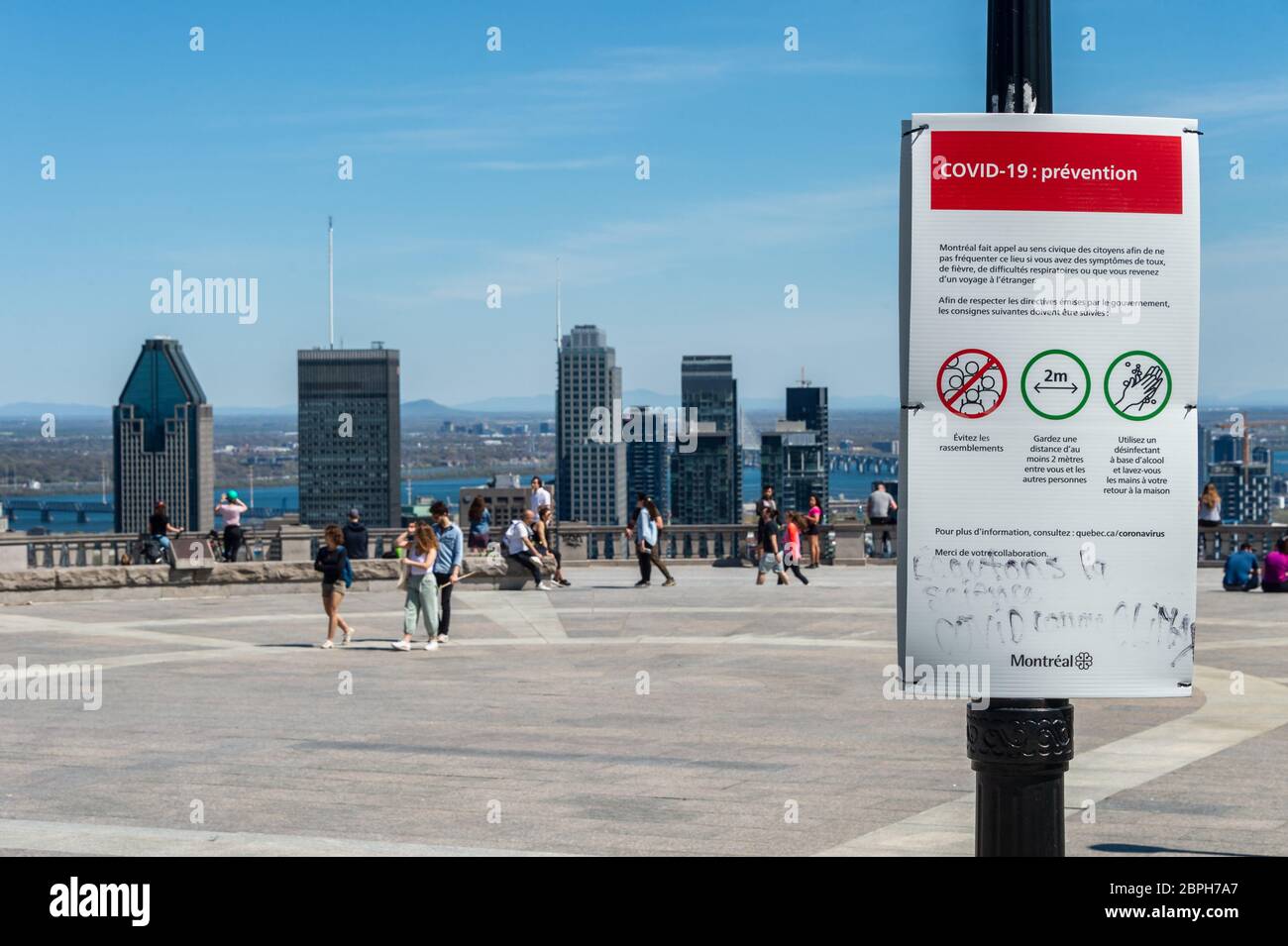 Montréal, CA - 18 mai 2020 : affiche montrant les lignes directrices françaises Covid-19 et les gratte-ciel de Montréal au loin. Banque D'Images