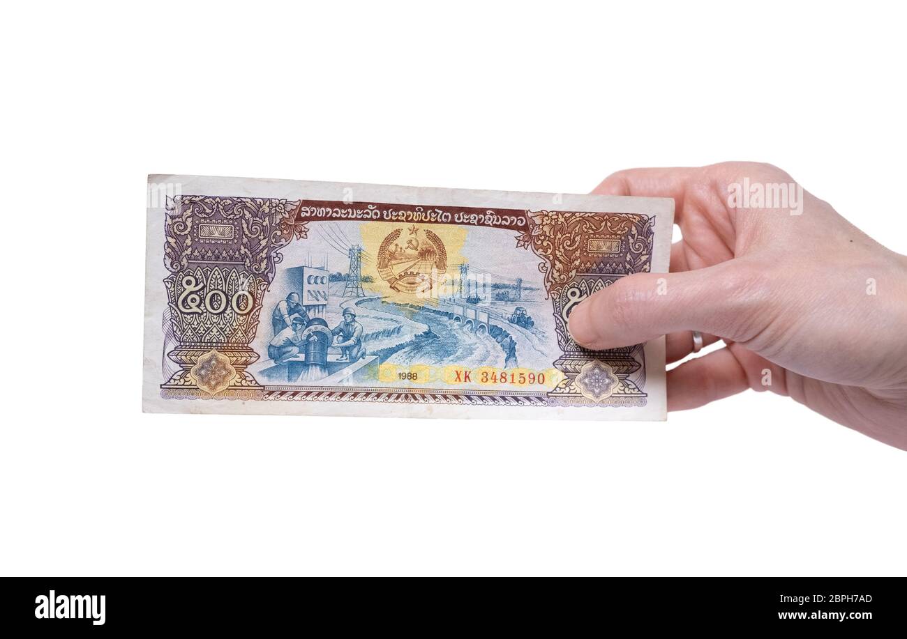 Main femelle tenant une monnaie de 500 KIP 1988 billets isolée sur fond blanc. Dénomination de 500 Kips. Banque D'Images
