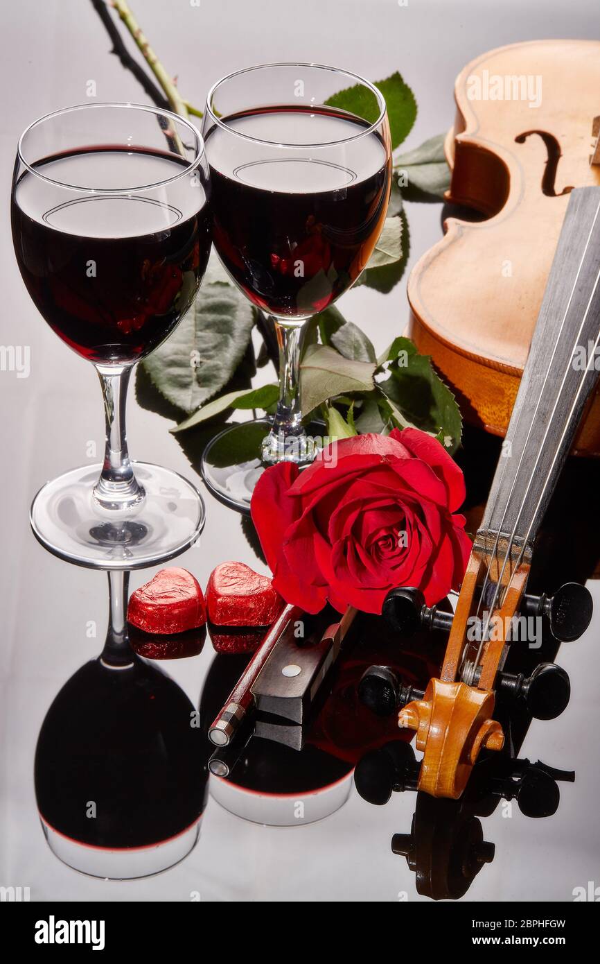 Violon (violon), cœur rouge, deux verres de vin et rose rouge sur fond noir. Instrument de chaîne. Saint Valentin. Banque D'Images