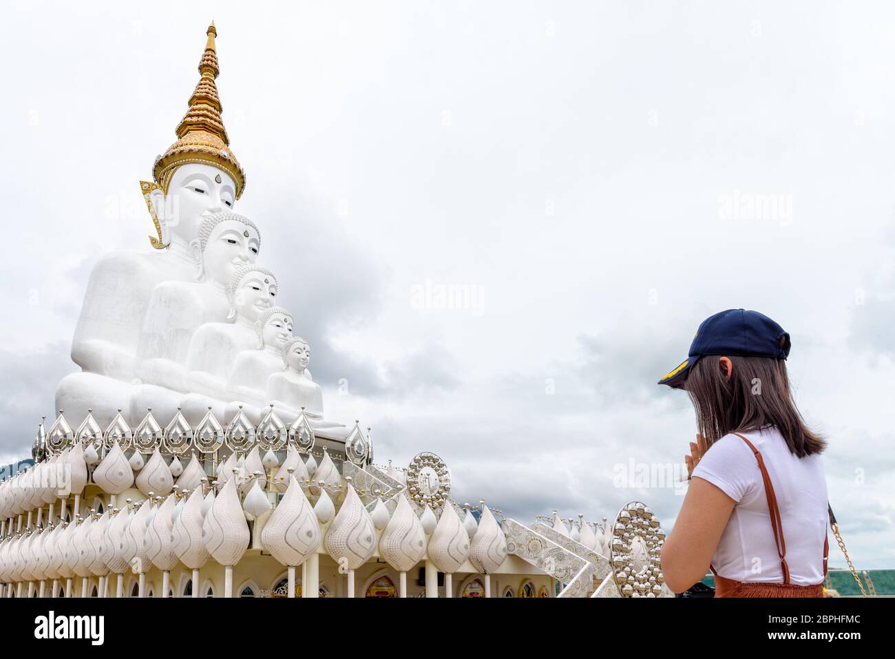 Femme debout priant pour ce qui concerne le culte avec la bénédiction de la statue de Bouddha a large white cinq corps au Wat Phra That Pha Sorn Kaew Temple est un célèbre tou Banque D'Images