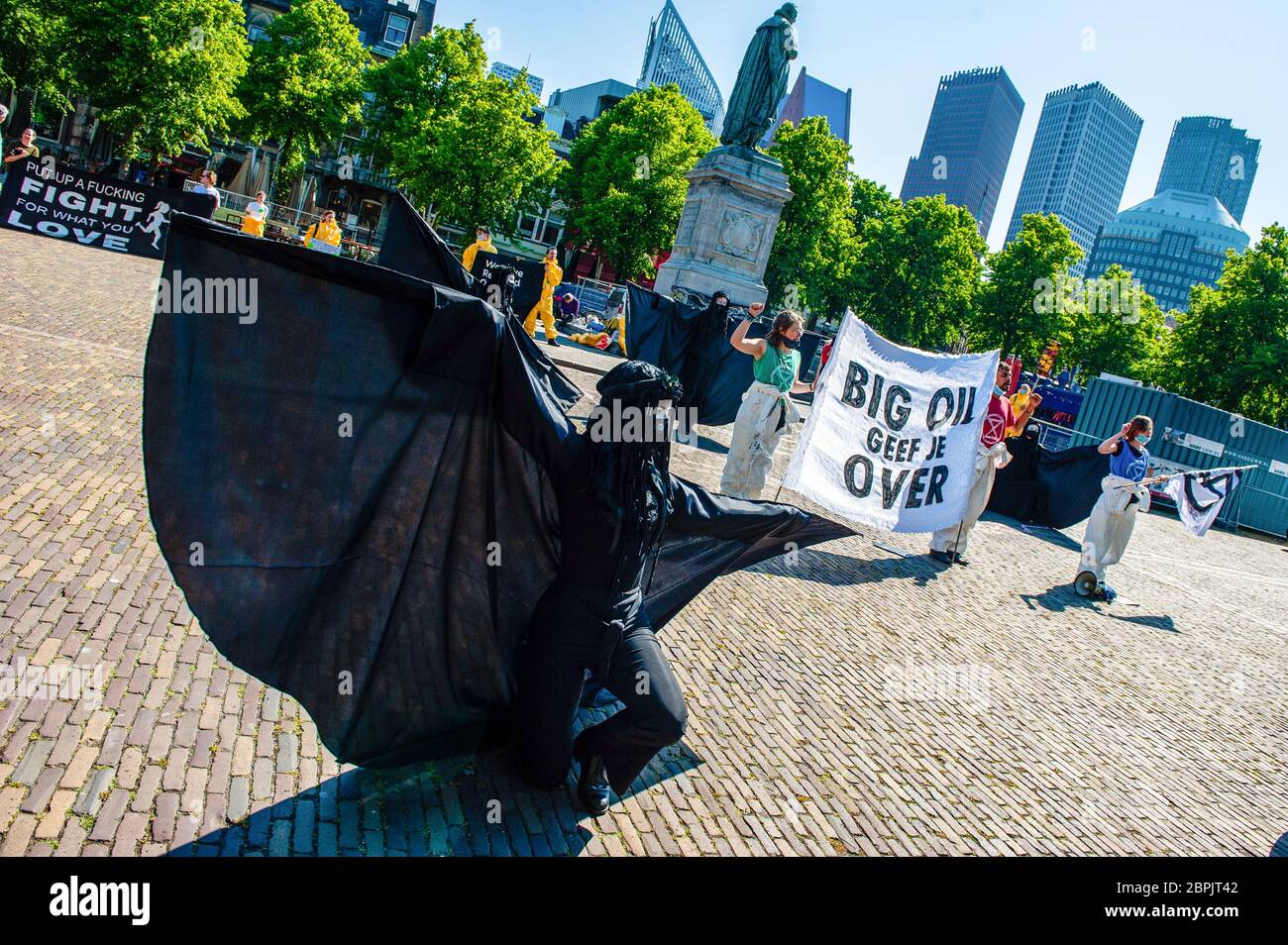 Un rebelle noir se produit autour de militants du climat qui détiennent une grande bannière. Lors de l'assemblée annuelle des actionnaires de Shell, le Code des groupes climatiques Rood, Shell doit tomber et Greenpeace a organisé une manifestation contre la compagnie pétrolière, devant le siège social de Shell. Les groupes climatiques ont protesté contre l'entreprise et ont exigé que l'entreprise soit démantelée. Le groupe climat, la rébellion de l'extinction, a également montré son soutien aux manifestations en menant une représentation avec les rebelles noirs devant la Chambre des représentants à la Haye. Les manifestations ont été entourées d'un grand pôle Banque D'Images