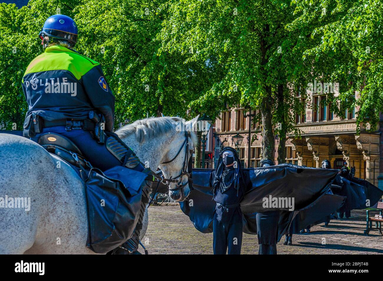 Les rebelles noirs sont vus répandre leurs ailes devant la police. Lors de l'assemblée annuelle des actionnaires de Shell, le Code des groupes climatiques Rood, Shell doit tomber et Greenpeace a organisé une manifestation contre la compagnie pétrolière, devant le siège social de Shell. Les groupes climatiques ont protesté contre l'entreprise et ont exigé que l'entreprise soit démantelée. Le groupe climat, la rébellion de l'extinction, a également montré son soutien aux manifestations en menant une représentation avec les rebelles noirs devant la Chambre des représentants à la Haye. Les manifestations ont été entourées par de hauts policiers Banque D'Images