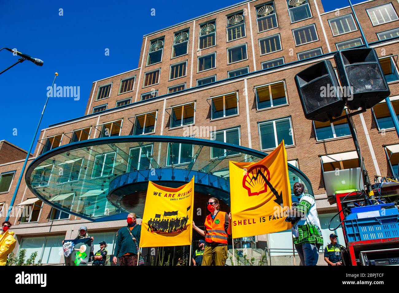 Les militants du climat sont vus brandissant des banderoles contre la compagnie pétrolière. Lors de l'assemblée annuelle des actionnaires de Shell, le Code des groupes climatiques Rood, Shell doit tomber et Greenpeace a organisé une manifestation contre la compagnie pétrolière, devant le siège social de Shell. Les groupes climatiques ont protesté contre l'entreprise et ont exigé que l'entreprise soit démantelée. Le groupe climat, la rébellion de l'extinction, a également montré son soutien aux manifestations en menant une représentation avec les rebelles noirs devant la Chambre des représentants à la Haye. Les manifestations ont été entourées par une forte présence policière Banque D'Images