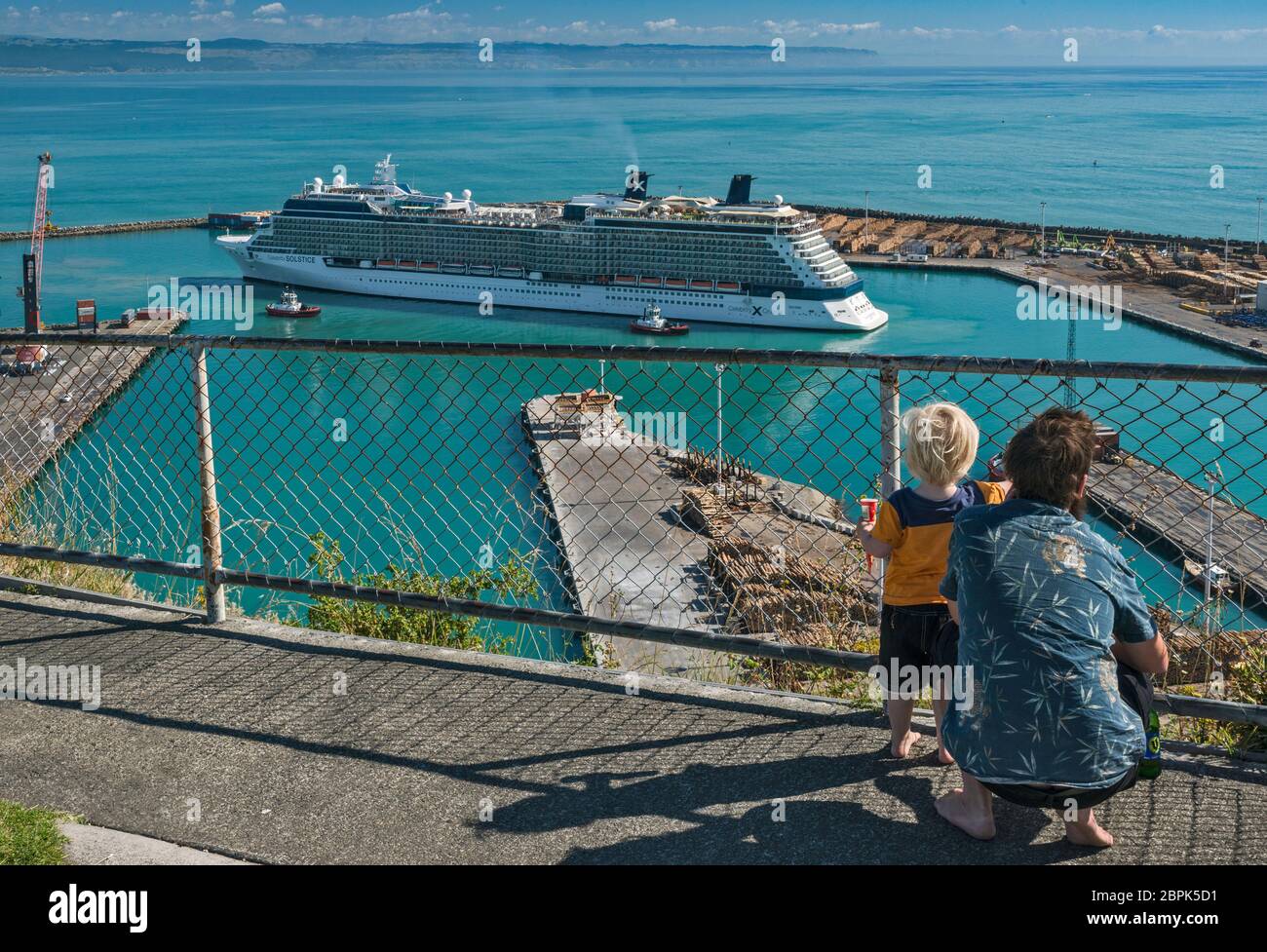Père et son fils regardant le bateau de croisière Celebrity Solstice entrant dans le port de Napier, région de Hawke's Bay, Île du Nord, Nouvelle-Zélande Banque D'Images