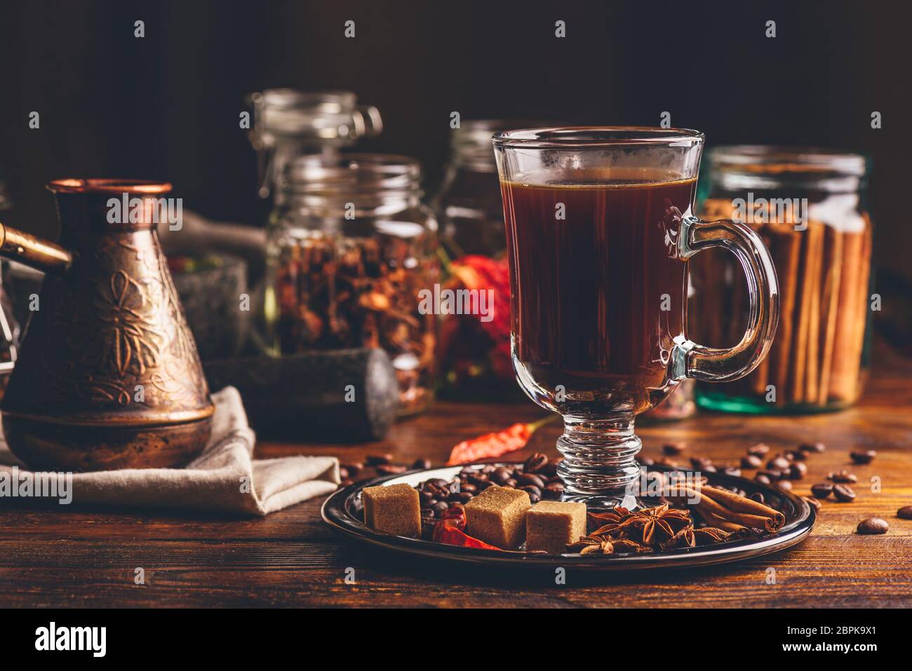 Cezve et verre de café avec des haricots, du sucre raffiné, l'anis étoilé, le bâton de cannelle et de piment. Banque D'Images