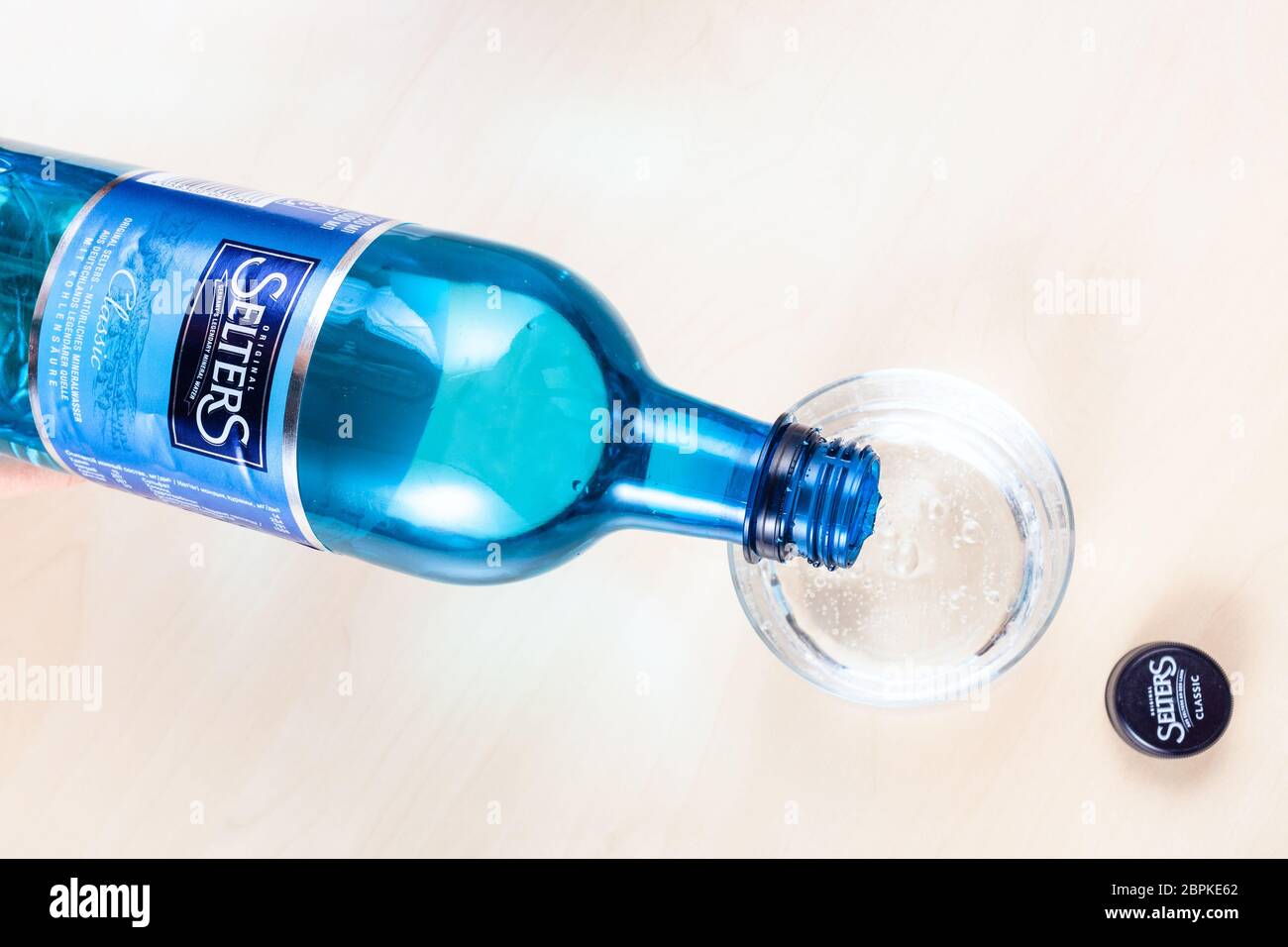 Une bouteille d'eau minérale de la société allemande Staatl. Fachingen sur  une table à côté d'un verre Photo Stock - Alamy