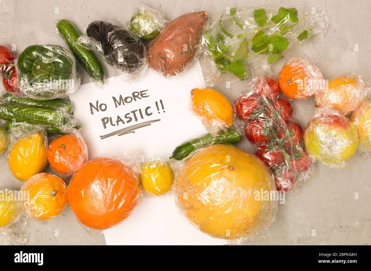 Beaucoup de différents fruits et légumes sont emballés dans un sachet en plastique, paniers sur fond de béton Banque D'Images