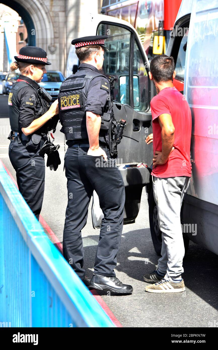 Ville de Londres deux policiers en uniforme parlant à des occupants masculins de camionnette blanche se sont arrêtés sur la route de Tower Bridge Southwark Londres Angleterre Royaume-Uni Banque D'Images