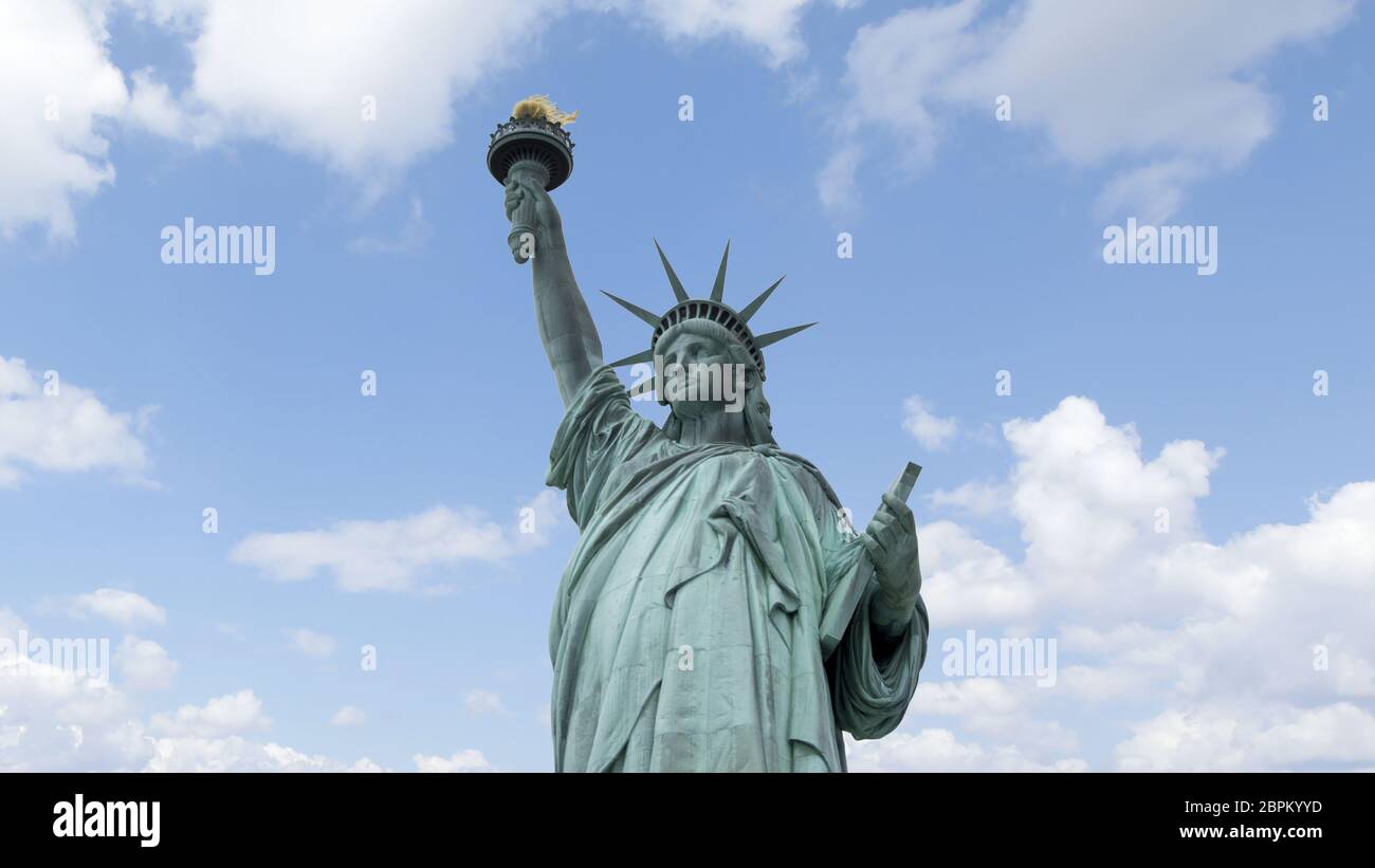 Statue de la liberté à New York avec ciel bleu et nuages derrière. Banque D'Images