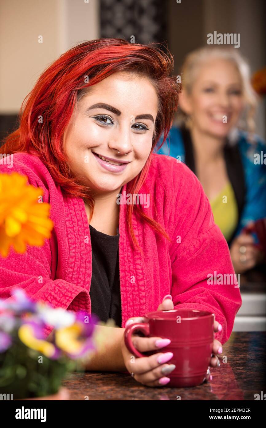 Une fille en robe sourit dans la cuisine Banque D'Images