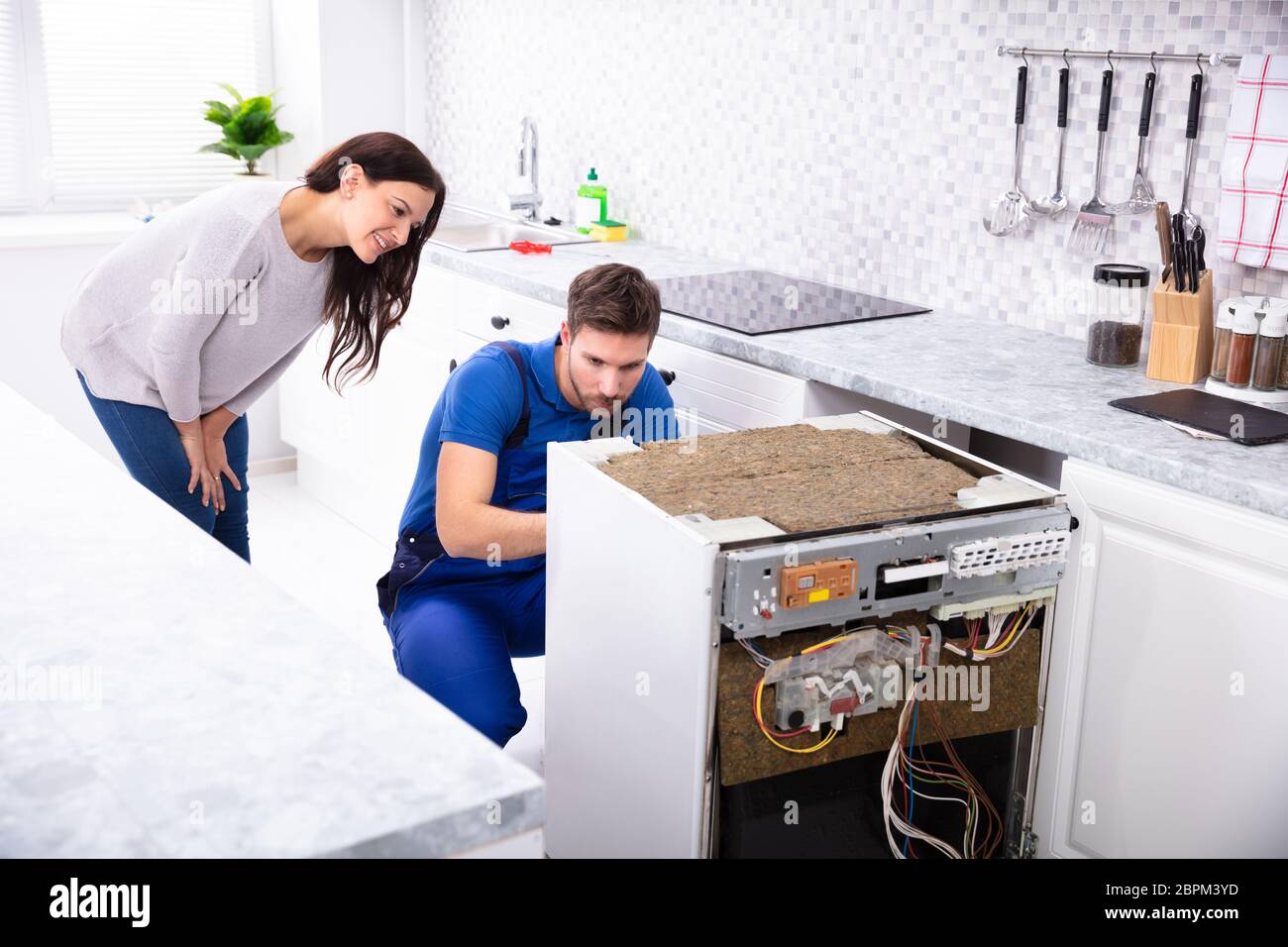 Femme derrière la réparation de lave-vaisselle dans la cuisine Technicien  Photo Stock - Alamy