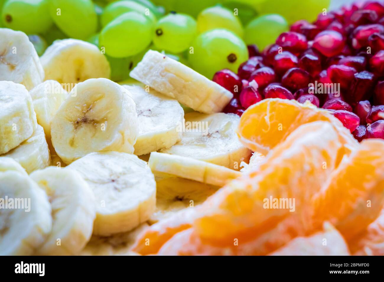 Concept de petit déjeuner sain. Fruits frais sur la table du petit déjeuner. Gros plan de raisins, banane, oranges, grenade. Mise au point sélective Banque D'Images