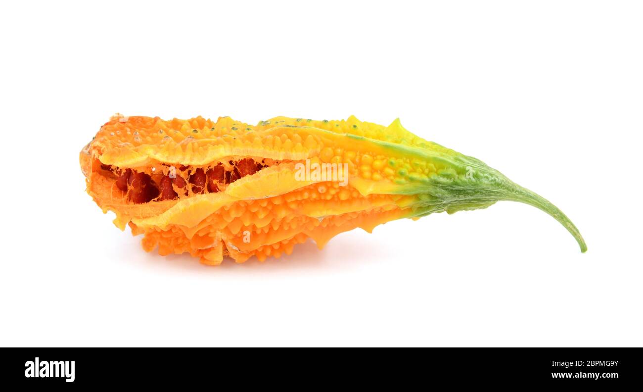 Melon amer mûr à la chair d'orange, en fend pour montrer des graines rouges collantes, isolées sur un fond blanc Banque D'Images