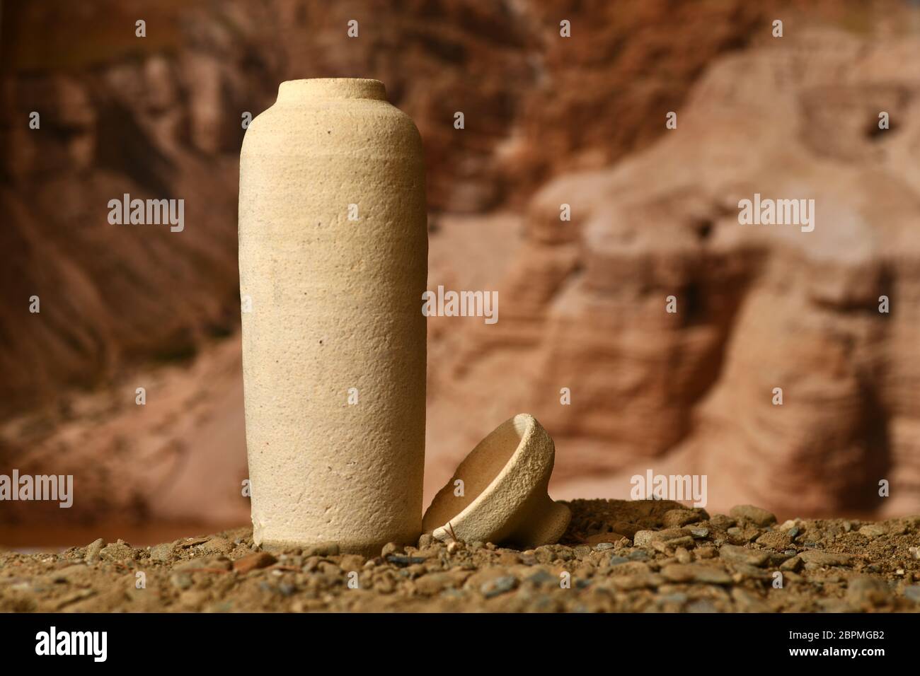 Un modèle de bocal utilisé pour la mer Morte défile sur un fond flou des grottes de Qumran Banque D'Images