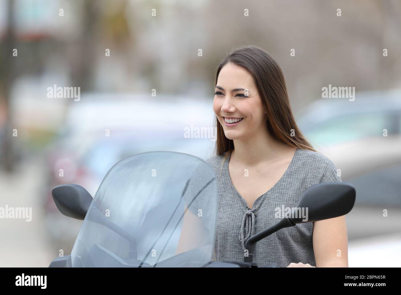 Fille de motards heureux assis sur une moto à l'écart dans la rue Banque D'Images