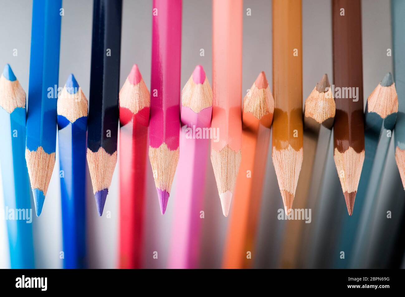 Close-up de crayon de couleur juxtaposés conseils sur un fond gris neutre. Banque D'Images