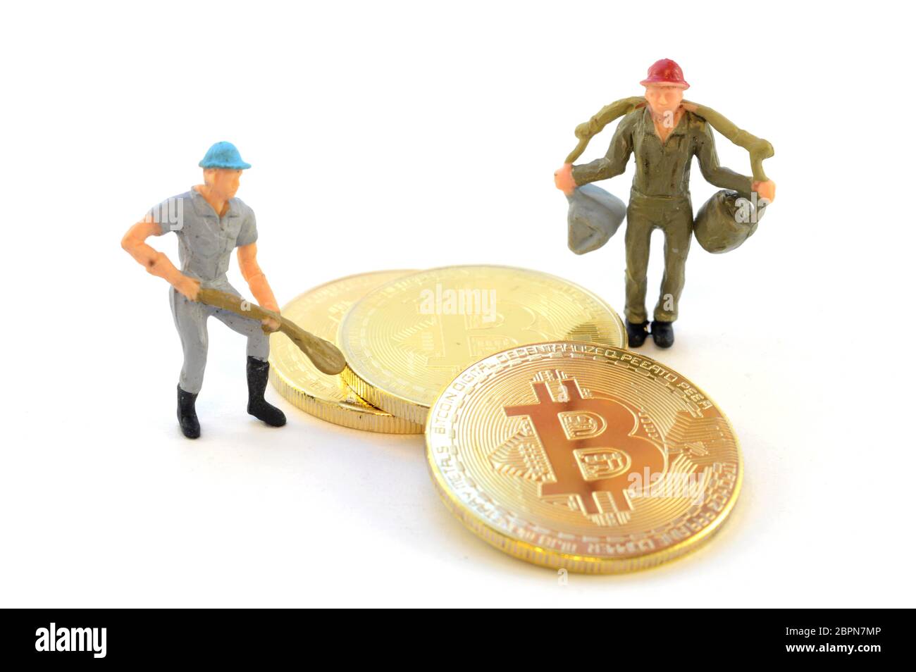 Image conceptuelle basée sur l'exploitation minière de monnaie numérique utilisant Bitcoin et une petite figurine. Banque D'Images