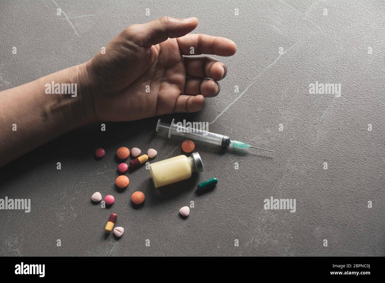 L'homme se suicide par une surdose de médicaments. Close up de surdosage comprimés et l'addict. Banque D'Images