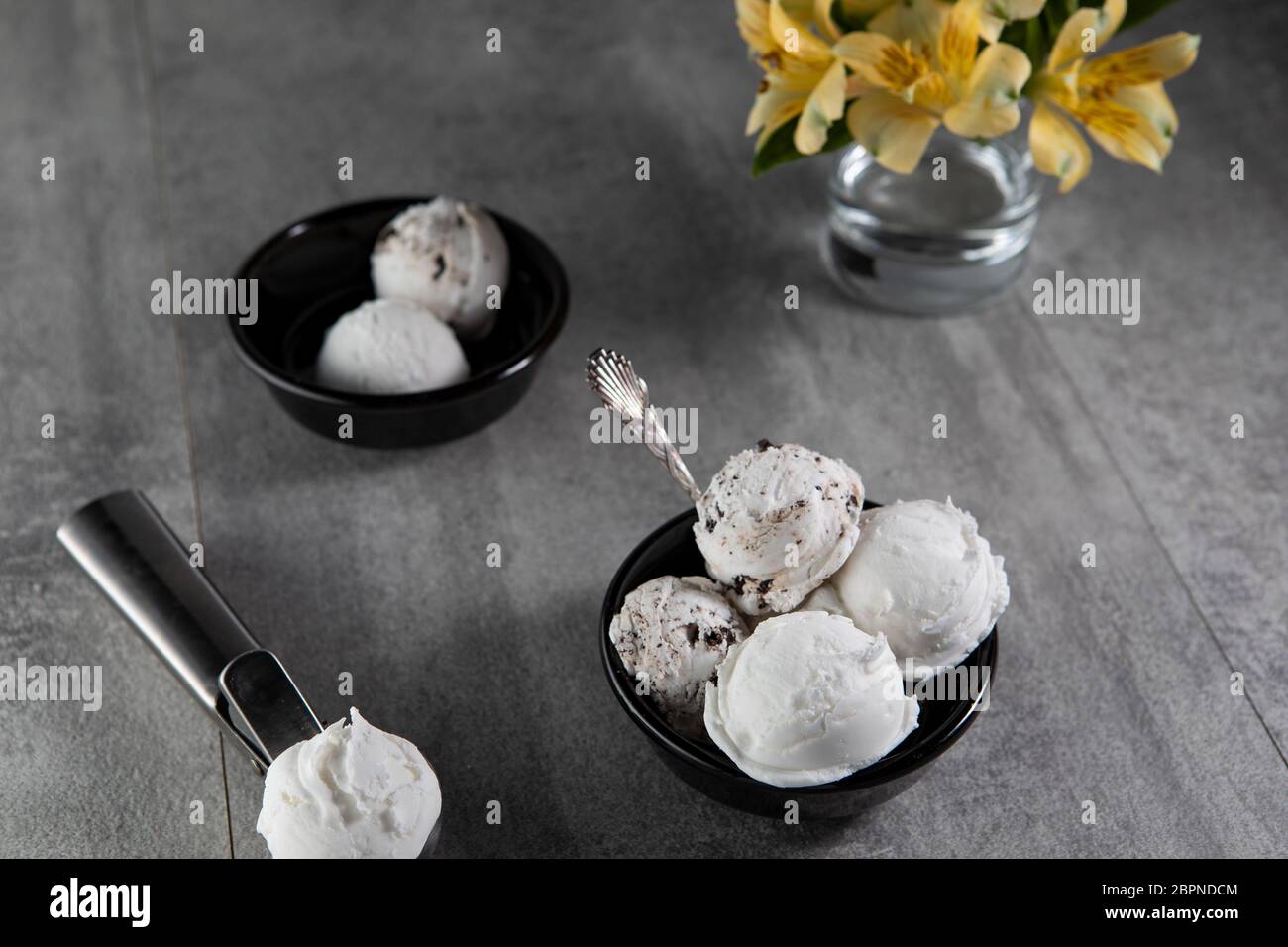 Crème glacée aux produits laitiers et à la stracciatella dans un bol à dessert noir Banque D'Images