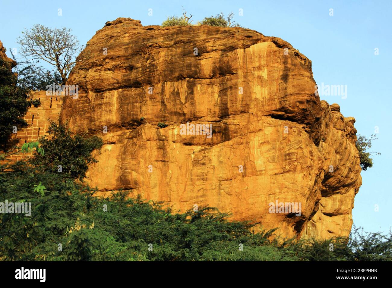 Gigantesque, jaune rougeâtre, déchirée par la météo rock surface sur le nord de l'hill à Badami dans quartier Bagalkot, Karnataka, Inde, Asie Banque D'Images