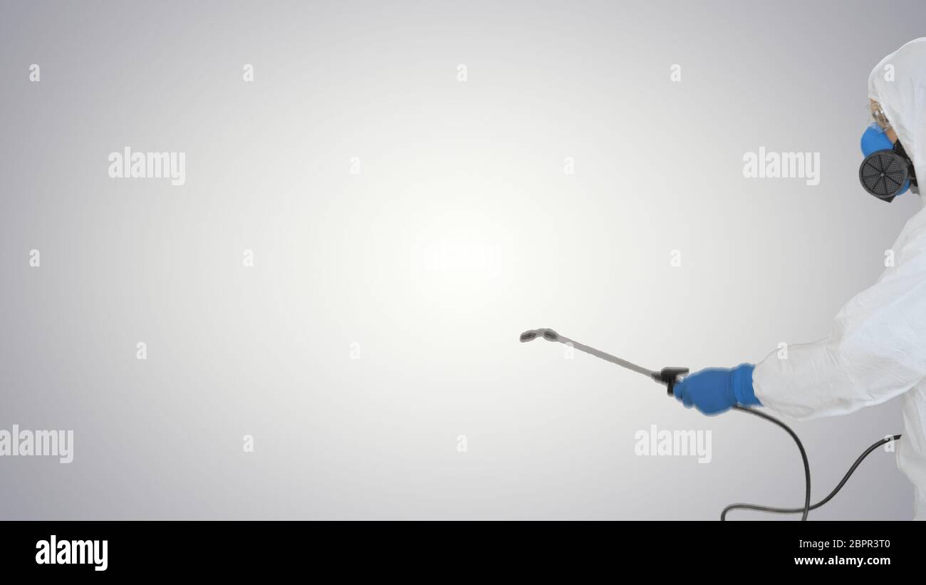 Désinfectant en combinaison protectrice faisant la désinfection sur fond gradient. Banque D'Images