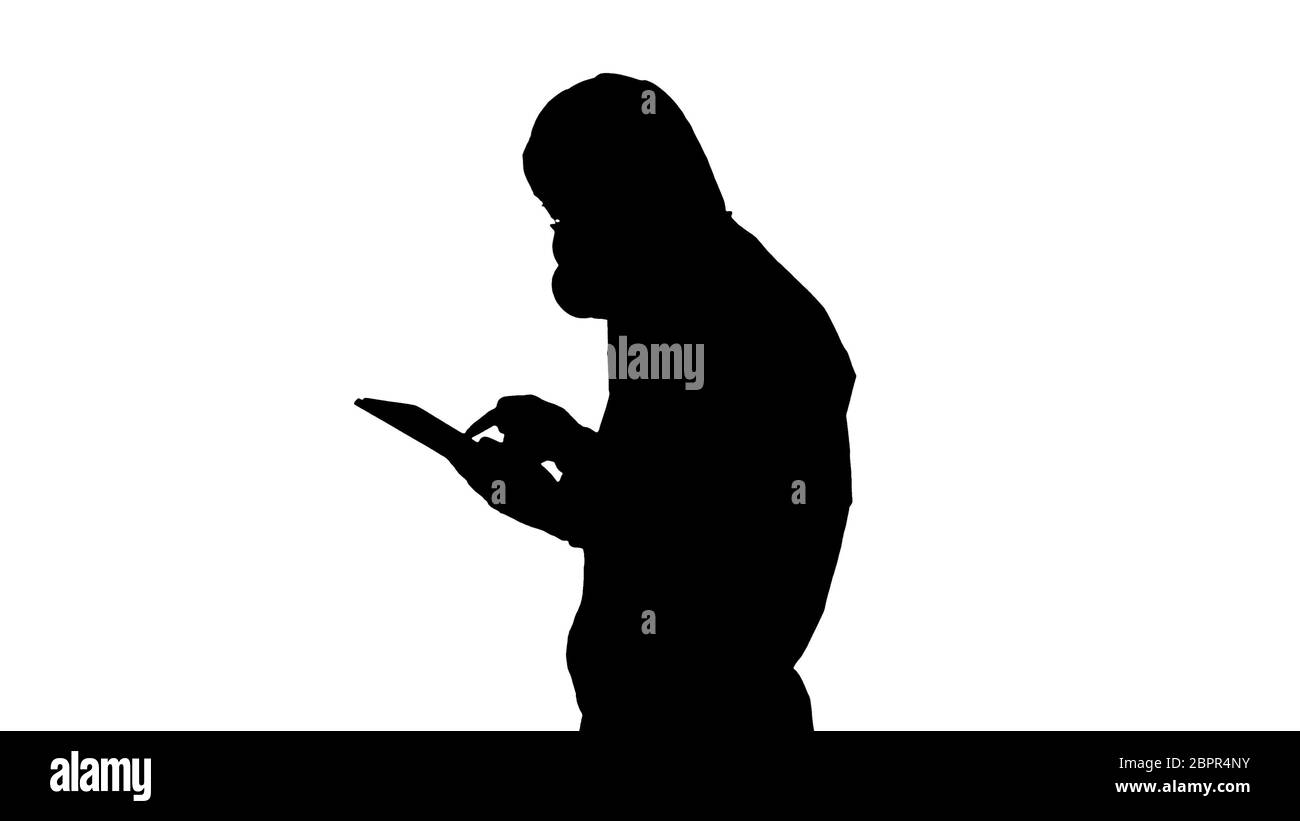 Silhouette Healthcare, un employé portant une combinaison de noisettes, travaillant sur une tablette numérique. Banque D'Images