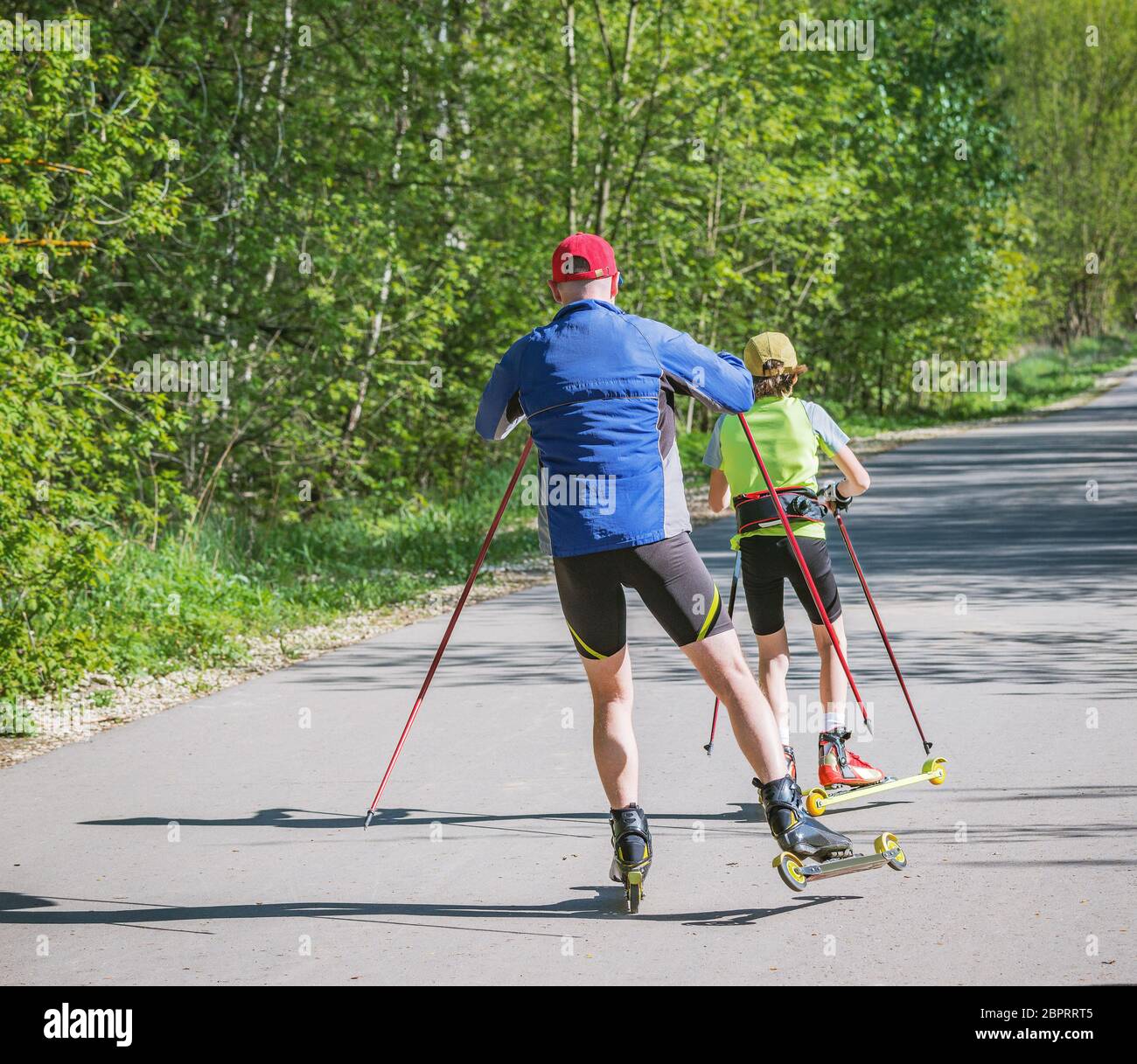 Père et fille s'entraîner sur les patineurs à roulettes. Banque D'Images