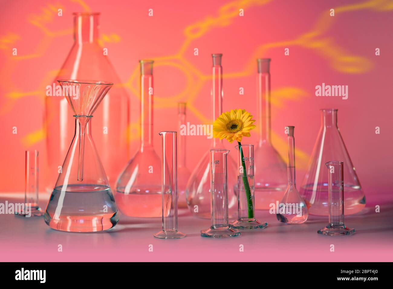 Variété de verrerie de laboratoire en partie rempli y compris le capitule dans l'ambiance rouge Banque D'Images