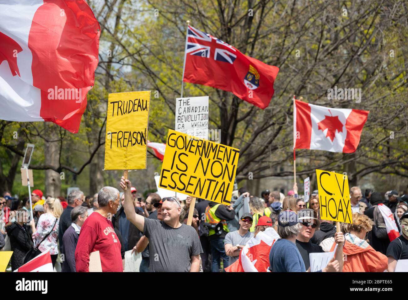 Les manifestants s'opposent au gouvernement à Queen's Park lors d'un rassemblement pour mettre fin à la fermeture de la COVID-19 à Toronto. Banque D'Images