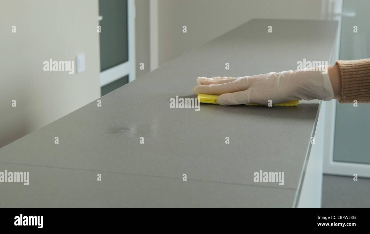 Désinfecter et désinfecter les surfaces avec un chiffon jaune contre le coronavirus et les bactéries. Hygiène personnelle et protection contre les maladies. Banque D'Images