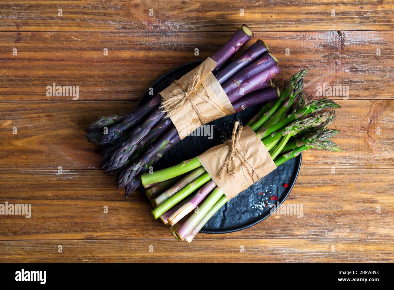 Frais naturel biologique deux paquets de légumes d'asperges verts et violets sur un fond en bois. Banque D'Images