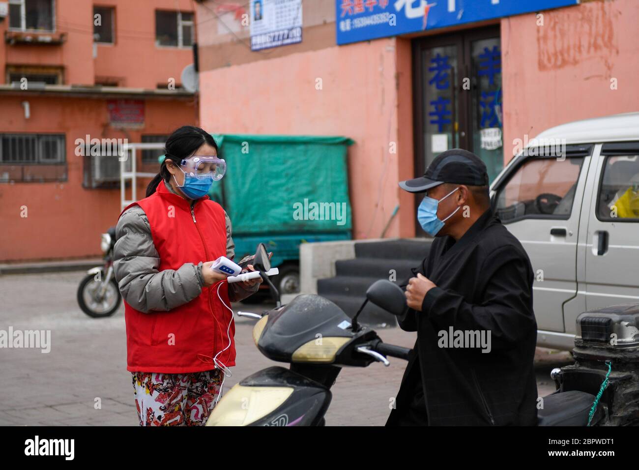 Jilin, province chinoise de Jilin. 19 mai 2020. Un travailleur communautaire vérifie la température corporelle d'un résident dans une collectivité de la zone de développement industriel de haute technologie de la ville de Jilin, dans la province de Jilin, au nord-est de la Chine, le 19 mai 2020. La province de Jilin, dans le nord-est de la Chine, a signalé quatre nouveaux cas confirmés de COVID-19 mardi, a déclaré la Commission nationale de la santé dans son rapport quotidien mercredi. Crédit: Yan Linyun/Xinhua/Alay Live News Banque D'Images