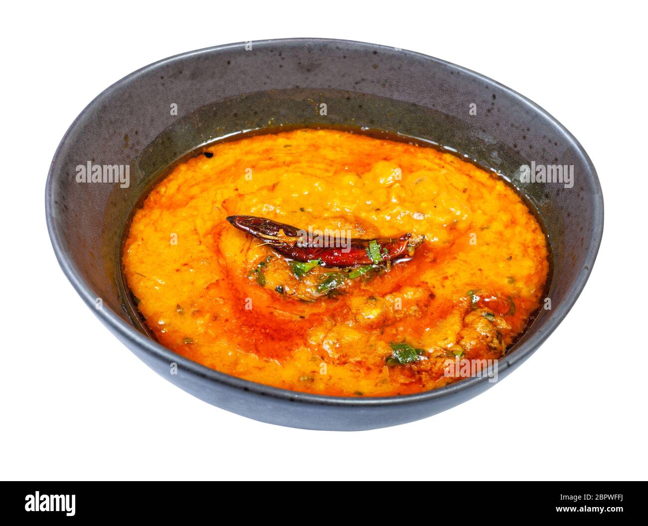 Cuisine indienne - portion de Dal Tadka jaune (chowder épicé doux et crémeux des lentilles au curry) dans un bol noir isolé sur fond blanc Banque D'Images