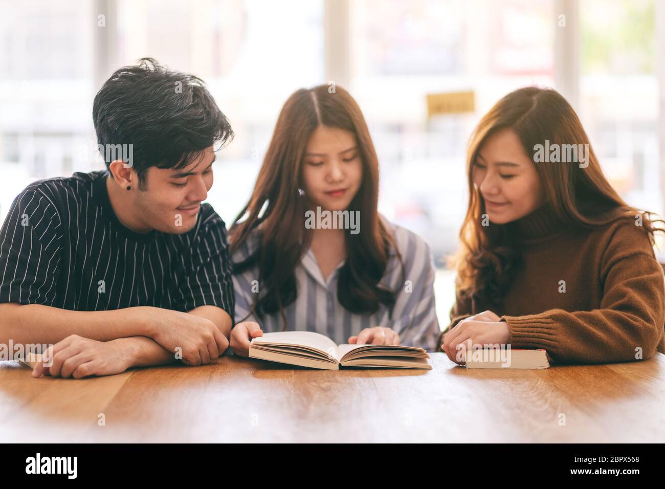 Groupe de jeunes personnes ont apprécié la lecture du même livre ensemble Banque D'Images