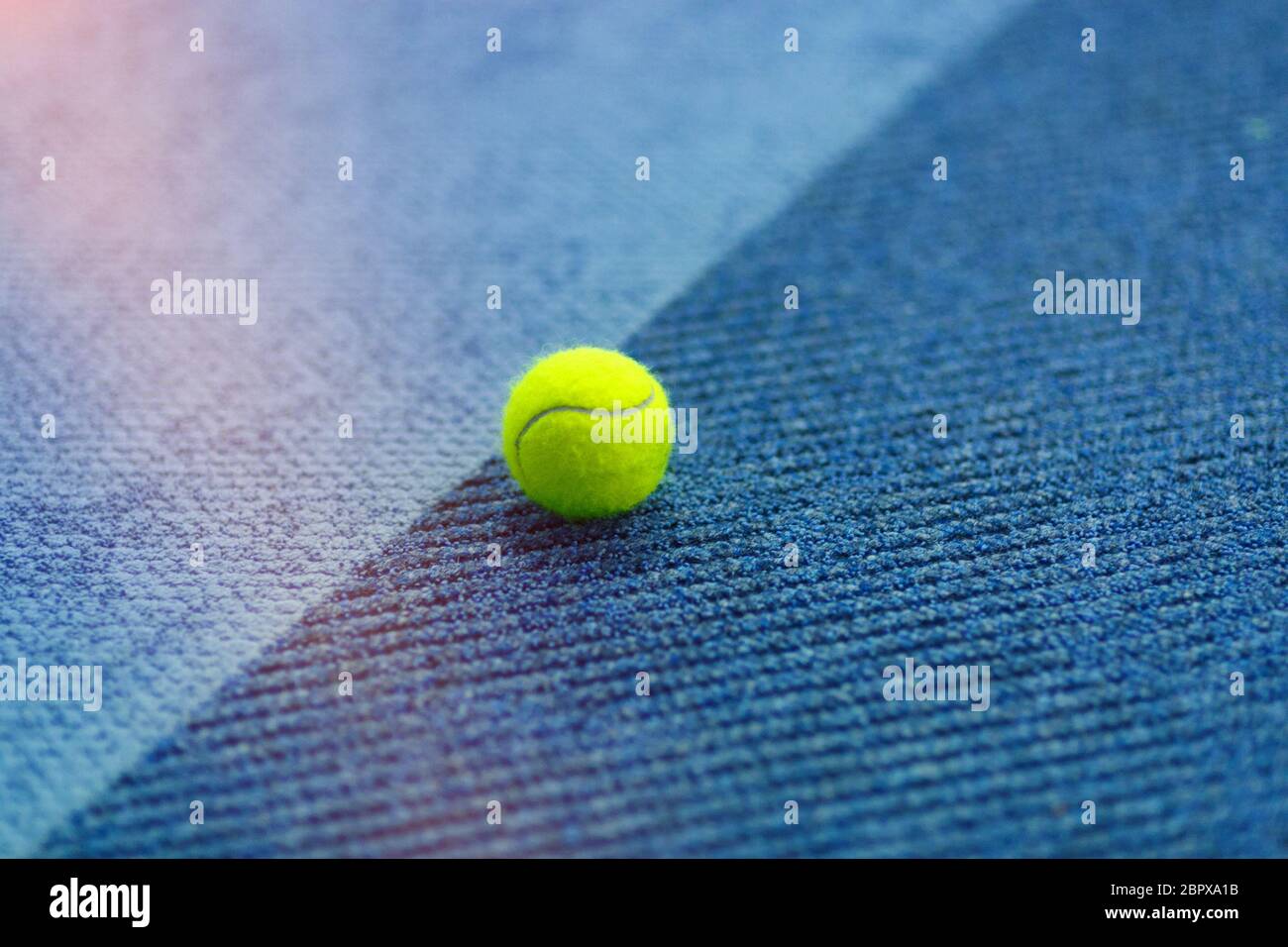Ballon de tennis jaune sur moquette d'intérieur bleu vif Photo Stock - Alamy