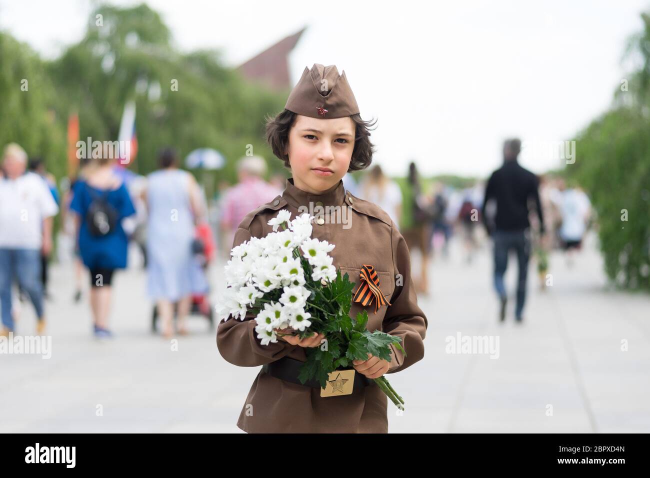 Portrait d'un garçon avec des fleurs, de l'uniforme d'un soldat de l'Armée rouge pendant la Seconde Guerre mondiale. Monument commémoratif de guerre soviétique (parc de Treptow), Berlin, Banque D'Images