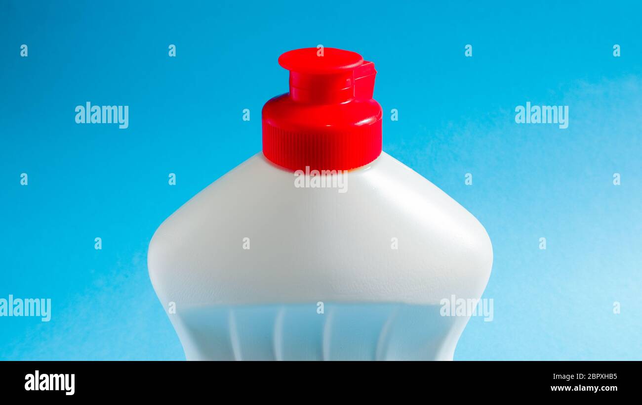 Bouteille en plastique blanc avec détergent à vaisselle, eau de Javel ou assouplissant sur fond bleu. Liquide de lavage en poudre. Le concept de nettoyage Banque D'Images