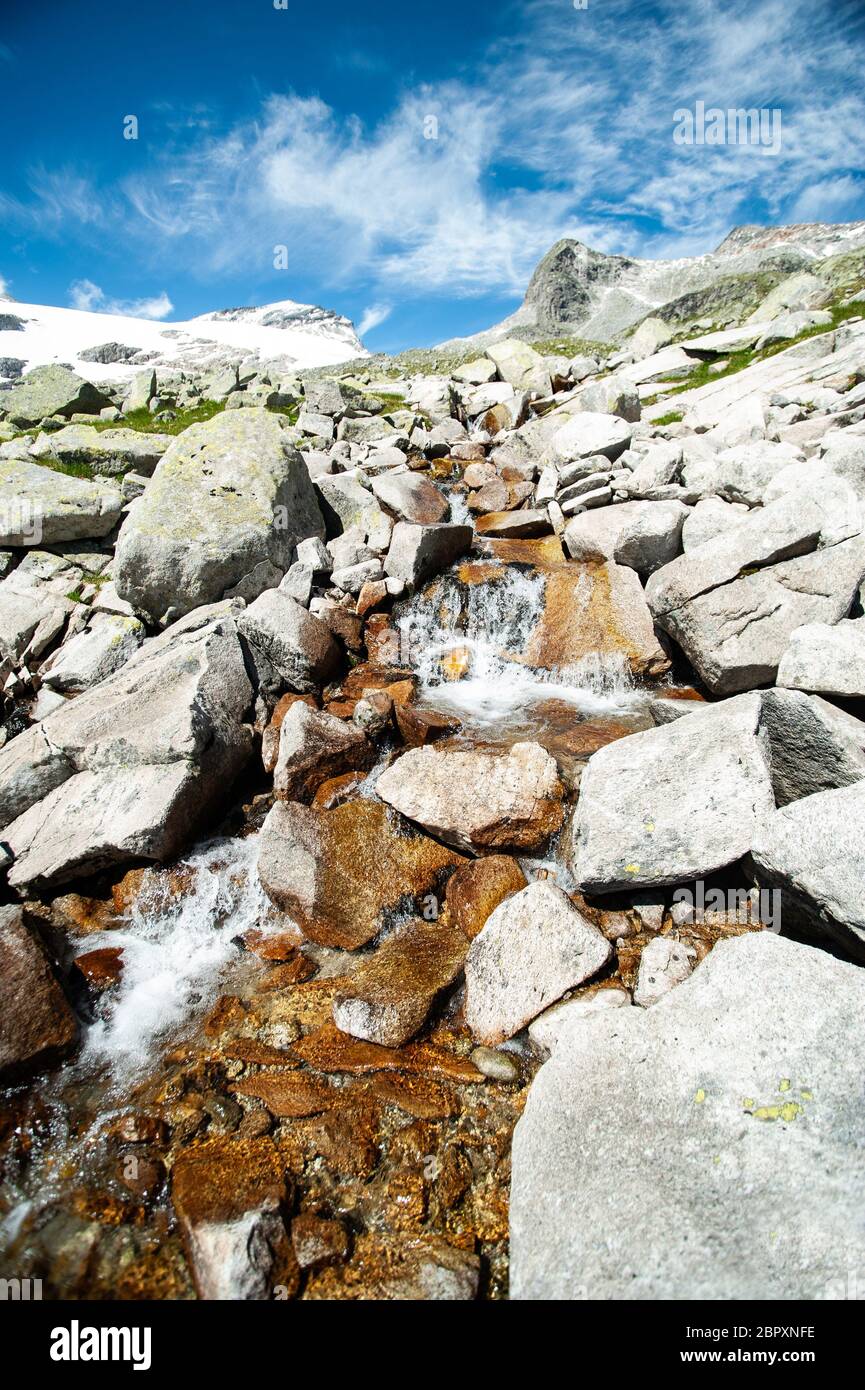 paysage des alpes, ruisseau sauvage en face des montagnes et ciel bleu Banque D'Images