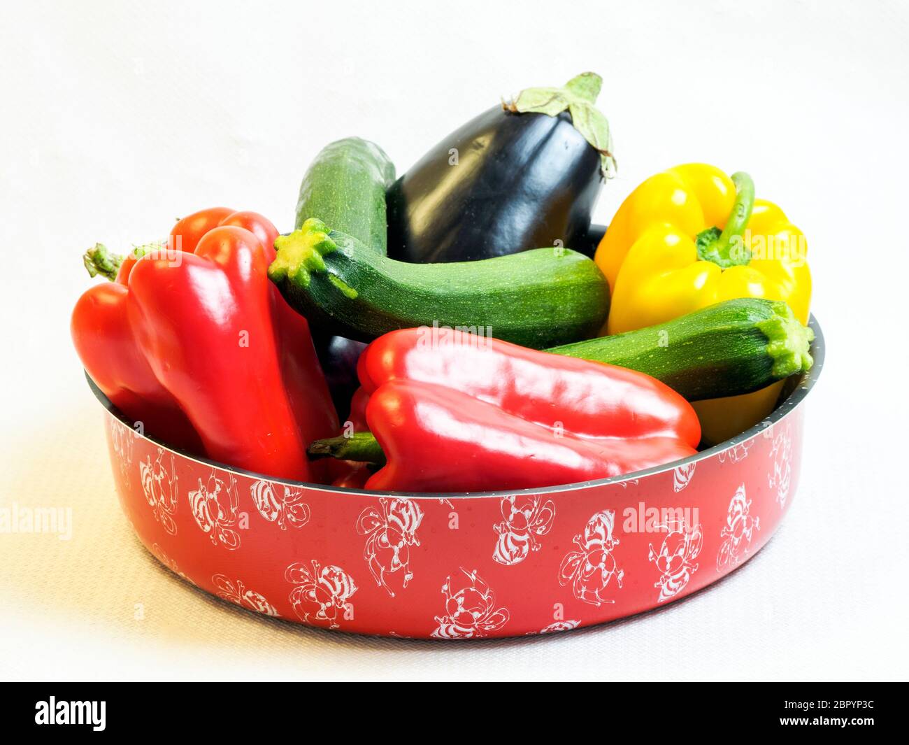 Aubergines, poivrons et courgettes dans un moule à pâtisserie Banque D'Images