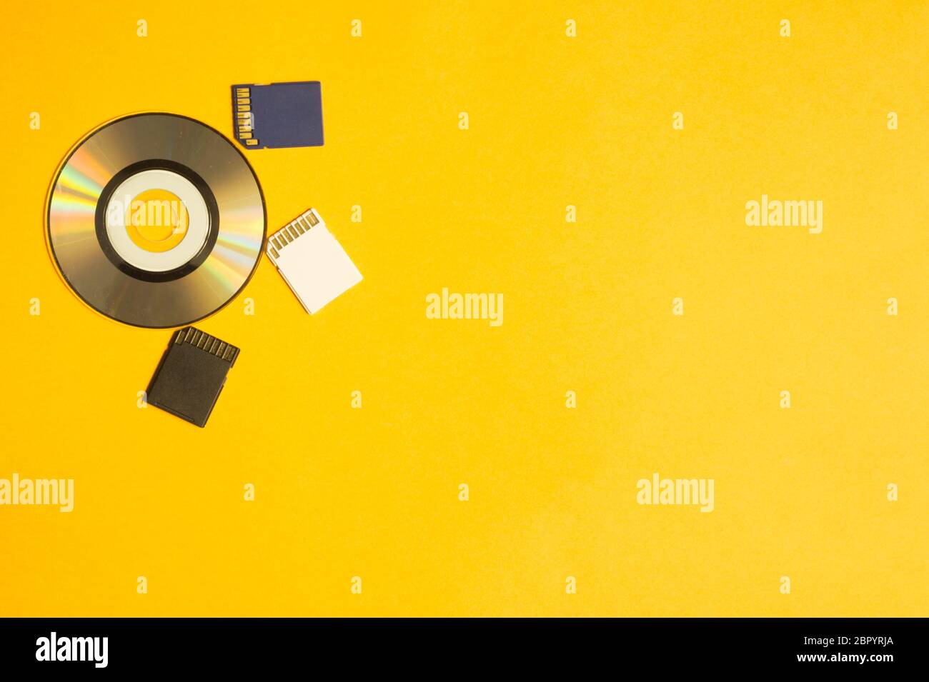 Carte mémoire et disque numérique isolés sur fond jaune. Carte sd et macro cd. Espace de copie Banque D'Images